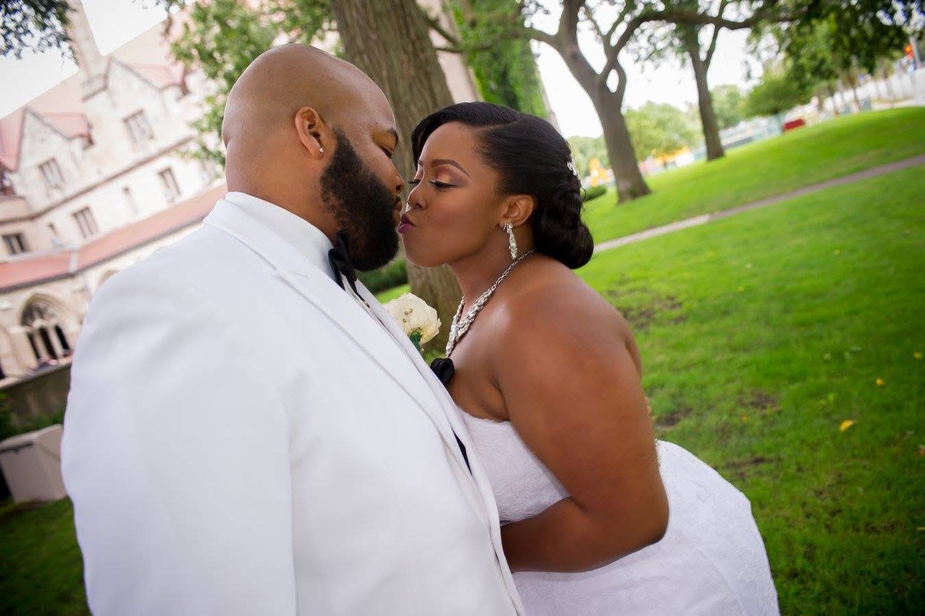 The couple sharing a kiss outdoors on their wedding day